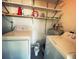 Compact laundry room featuring washer, dryer, and storage shelves at 535 Lindley Ter, Port Charlotte, FL 33952