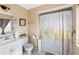Bathroom with white vanity, toilet and shower/tub with white and gold shower curtain at 558 Azalea Drive, Port Charlotte, FL 33952