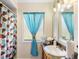 Bathroom features a shower with blue curtain, and a vanity with decorative accents at 558 Azalea Drive, Port Charlotte, FL 33952
