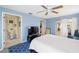 Bedroom with blue walls, ceiling fan, and doorways to bathroom and sitting room at 558 Azalea Drive, Port Charlotte, FL 33952