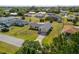 Attractive aerial view of a tan home showcasing its well-kept lawn and welcoming curb appeal at 558 Azalea Drive, Port Charlotte, FL 33952