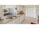 Bright kitchen featuring white cabinets, stainless steel sink and view of Gathering room at 558 Azalea Drive, Port Charlotte, FL 33952