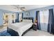 Bright primary bedroom featuring a comfortable bed, dark furniture, and soothing blue walls with a sunroom access at 558 Azalea Drive, Port Charlotte, FL 33952
