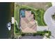 Aerial view of the property showcasing the home, pool, waterfront location, and boat dock with boat at 571 Port Bendres Dr, Punta Gorda, FL 33950