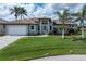 Beautiful single-story home features a tile roof, front lawn, driveway, landscaping, and an attached garage at 571 Port Bendres Dr, Punta Gorda, FL 33950