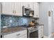 Charming kitchen boasts updated appliances, beautiful backsplash and countertops, and ample cabinet space at 571 Port Bendres Dr, Punta Gorda, FL 33950