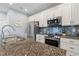 Open kitchen features stainless steel appliances, granite countertops, and a beautiful mosaic backsplash at 571 Port Bendres Dr, Punta Gorda, FL 33950