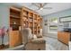 Cozy office/den featuring custom built-in bookshelves, comfortable seating, and natural light at 571 Port Bendres Dr, Punta Gorda, FL 33950