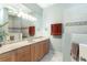 Bright bathroom with wood cabinets, neutral countertops, and a large mirror at 584 Toulouse Dr, Punta Gorda, FL 33950