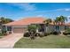 Inviting home showcasing manicured lawn, lush landscaping, brick-paved driveway, and an attached two-car garage at 584 Toulouse Dr, Punta Gorda, FL 33950
