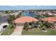 Beautiful waterfront home featuring a tile roof, brick driveway, two-car garage, and well-maintained landscaping at 584 Toulouse Dr, Punta Gorda, FL 33950