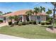 Charming single-story home featuring a tile roof, lush landscaping, and a well-manicured lawn at 584 Toulouse Dr, Punta Gorda, FL 33950