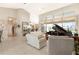 Bright living room featuring neutral decor, tile flooring, and views of the outdoor waterfront through large windows at 584 Toulouse Dr, Punta Gorda, FL 33950