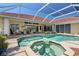 An inviting screened-in pool and hot tub area with tile surround, steps and plenty of room for outdoor furniture at 584 Toulouse Dr, Punta Gorda, FL 33950