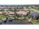 Aerial view of the home's rear exterior including screened pool, boat dock, and canal access at 584 Toulouse Dr, Punta Gorda, FL 33950