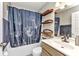 Bathroom featuring vanity, toilet, bathtub with shower and decorative shower curtain and shelves at 6344 Hera St, Englewood, FL 34224