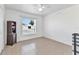 Bright bedroom with neutral tile flooring, a ceiling fan, and a large window overlooking the yard at 6344 Hera St, Englewood, FL 34224