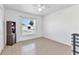 Bright bedroom with neutral tile flooring, a ceiling fan, and a large window overlooking the yard at 6344 Hera St, Englewood, FL 34224