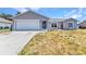 Single-story home featuring a neutral color scheme, an attached garage, and a well-maintained lawn at 6344 Hera St, Englewood, FL 34224