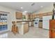A traditional kitchen with tile floors, wooden cabinets, white appliances, and a breakfast bar with seating at 6344 Hera St, Englewood, FL 34224