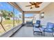 Enclosed patio featuring an ornate ceiling fan and comfortable seating with a view of the backyard at 6344 Hera St, Englewood, FL 34224