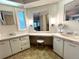 Spacious bathroom with dual sinks, vanity area, and plenty of natural light from the adjacent window at 749 Watersedge St, Englewood, FL 34223