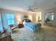 Spacious bedroom with a comfortable bed, a chair by the window, and mirrored closet doors at 749 Watersedge St, Englewood, FL 34223