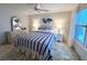 Cozy bedroom featuring a blue and white striped comforter, matching lamps, and a ceiling fan at 749 Watersedge St, Englewood, FL 34223