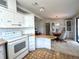 Cozy kitchen with white appliances and cabinets that seamlessly flows into the dining area at 749 Watersedge St, Englewood, FL 34223