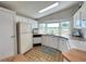 Bright kitchen with white cabinets and appliances boasts water views from the bay window over the sink at 749 Watersedge St, Englewood, FL 34223