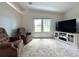 This cozy living room has plush seating, large windows overlooking the water, and an entertainment center at 749 Watersedge St, Englewood, FL 34223