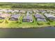 Aerial view of multiple homes with screened-in pools along a scenic lake at 8968 Artisan Way, Sarasota, FL 34240