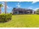Well-manicured backyard with a spacious screened-in lanai and lush green lawn at 8968 Artisan Way, Sarasota, FL 34240