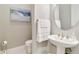 Bathroom featuring modern fixtures, a pedestal sink, and decorative art at 8968 Artisan Way, Sarasota, FL 34240