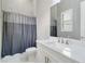 Bathroom features marble floors, shower with curtain, and large mirror at 8968 Artisan Way, Sarasota, FL 34240