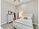 Neutral bedroom features a white bed, a dresser with a mirror, and light grey carpeting at 8968 Artisan Way, Sarasota, FL 34240