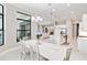 Bright dining room featuring a modern chandelier, large windows, and an open floor plan leading to the kitchen at 8968 Artisan Way, Sarasota, FL 34240