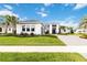 Beautiful single-Gathering home featuring a lush lawn and a paved driveway under a blue sky with clouds at 8968 Artisan Way, Sarasota, FL 34240