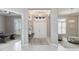 An elegant foyer with high ceilings, white tile floors, and a view of the office and living room at 8968 Artisan Way, Sarasota, FL 34240