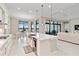 Kitchen with large island, stainless appliances, and a view of the dining and living areas at 8968 Artisan Way, Sarasota, FL 34240
