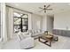 Bright, modern living room with a large window, a gray sofa, a wet bar, and tile floors at 8968 Artisan Way, Sarasota, FL 34240