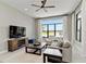 Bright living room featuring a water view, comfortable seating, and a ceiling fan at 8968 Artisan Way, Sarasota, FL 34240