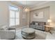 Cozy living room with a gray sofa, chair, and a round coffee table next to a large window at 8968 Artisan Way, Sarasota, FL 34240