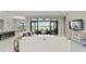 Open concept living space with kitchen island, living room, and access to outdoor living space at 8968 Artisan Way, Sarasota, FL 34240