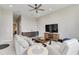 Living room with a wet bar, large TV, ceiling fan, tile flooring, and neutral-toned furniture at 8968 Artisan Way, Sarasota, FL 34240