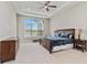 Spacious main bedroom with a tray ceiling, large windows, and an ensuite bathroom at 8968 Artisan Way, Sarasota, FL 34240