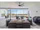 Inviting screened patio featuring comfortable seating, ceiling fan, and tranquil lake views at 8968 Artisan Way, Sarasota, FL 34240
