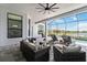 Relaxing screened lanai with stylish wicker furniture, lounge chairs, and serene waterfront view at 8968 Artisan Way, Sarasota, FL 34240