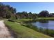 Scenic view of a serene pond surrounded by lush greenery in the community at 8968 Artisan Way, Sarasota, FL 34240