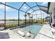 Sparkling pool in a screened enclosure with lush landscaping and scenic water views at 8968 Artisan Way, Sarasota, FL 34240
